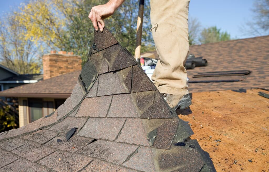 Asphalt shingles being removed by a professional roofer to start the roof replacement process