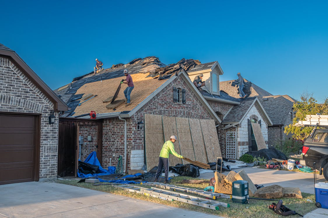Homeowner removing heavy snow buildup from a roof during Wisconsin winter conditions.