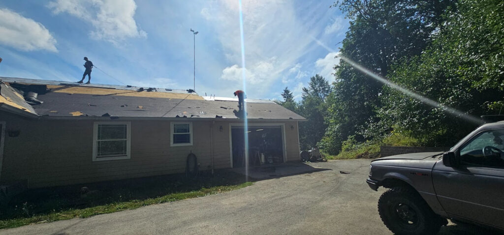 Roofing crew performing roof tear off during replacement in Fitchburg WI